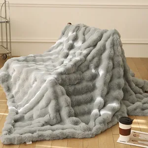 Vue détaillée d'une couverture grise en fausse fourrure de lapin avec texture à bulles