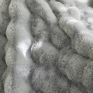 Détail rapproché d'une couverture douce en fausse fourrure de lapin grise et blanche