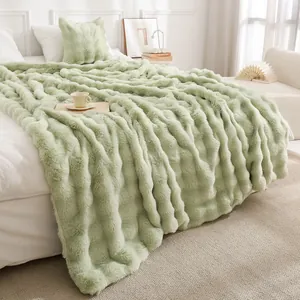 Luxueuse couverture en fausse fourrure de lapin Toscane vert clair sur un lit blanc douillet