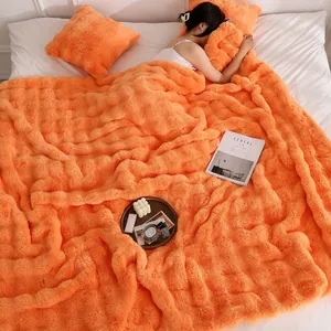 Vue détaillée de la couverture orange ultra-douce en fausse fourrure à texture bulles.