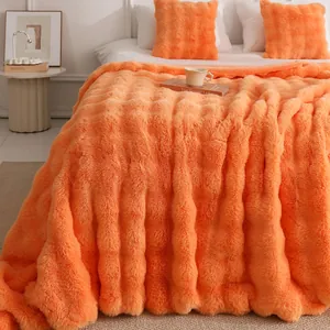 Gros plan sur une couverture orange vif en fausse fourrure à texture de bulles