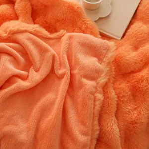 Gros plan d'une couverture en fausse fourrure de lapin orange douce avec une texture moelleuse.