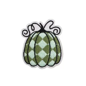 Artistic pumpkin embroidered patch with green checkered pattern for bag decoration.