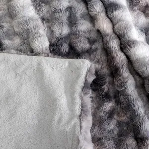 Détail macro de la texture douce en fausse fourrure de lapin grise de cette couverture