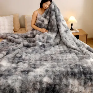 Couverture ultra douce en fausse fourrure de lapin tie-dye gris dans une chambre cosy