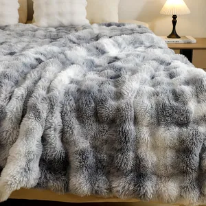 Gros plan d'une couverture en peluche dégradée grise avec une texture à bulles douces