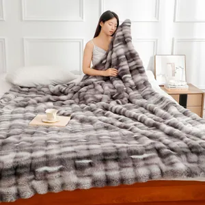 Couverture épaisse en fausse fourrure de lapin gris doux avec texture à bulles dans une chambre