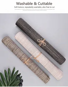 Woven PVC placemats set in brown and cream rolled with twine ties for heat resistant dining