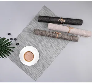 Close-up of heat-resistant PVC woven placemats in multiple colors with coffee cup.