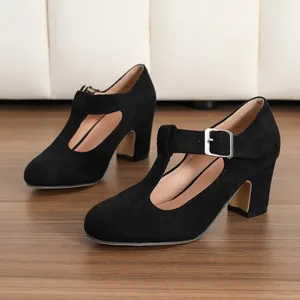 Dettaglio di eleganti scarpe Mary Jane in camoscio nero con tacco largo su legno