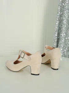 Vista dettagliata delle eleganti scarpe Mary Jane beige con cinturino a T e tacco alto largo.