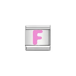 Detailed macro view of a polished stainless steel Italian charm with pink letter F