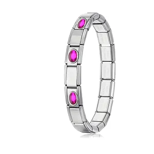 Macro detail of a stainless steel modular charm bracelet with vibrant pink oval gemstones