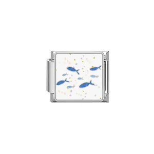 Detalle de módulo de pulsera italiana con diseño de peces azules y confeti de colores