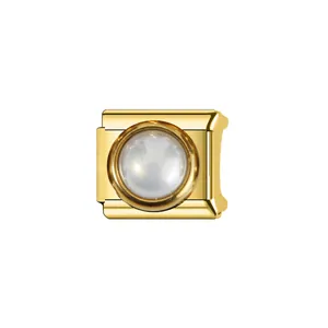 Détail d'un maillon de charme italien en acier doré avec une perle blanche ronde.