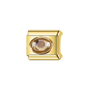 Détail d'un charm modulaire italien en acier doré avec une pierre ovale de couleur champagne