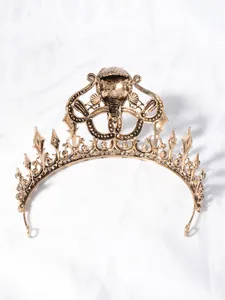Gedetailleerd beeld van vintage gouden kroon met kobrakopontwerp en groene stenen