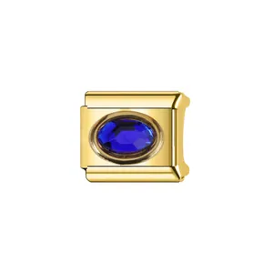 Détail macro d'un maillon de charme italien en or poli avec un cristal bleu ovale