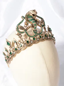 Gedetailleerd overzicht van een luxe vintage slangendiadeem met groene strass