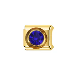 Gros plan d'un lien de breloque italienne en or avec un zircon saphir bleu rond.
