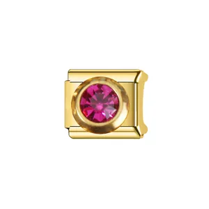 Gros plan d'un module de bracelet italien en acier doré avec une pierre de naissance rose facettée.