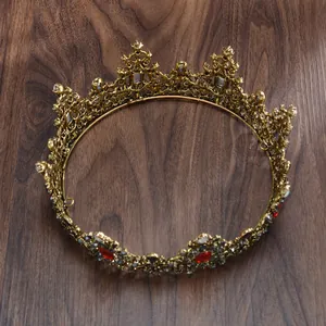 Exclusief detail van een luxe barokke bruidskroon in antiek goud met rode strass-steentjes