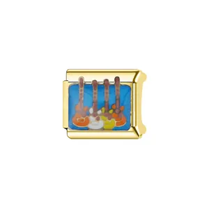 Detailed macro shot of a golden Italian modular charm with colorful guitar pattern