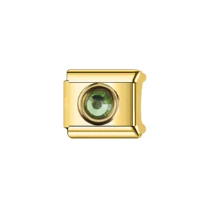 Détail d'un charm de bracelet modulaire italien doré orné d'une pierre de naissance verte