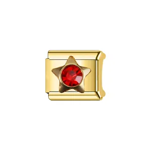Détail en gros plan d'un charm modulaire italien doré orné d'une étoile en pierre rouge