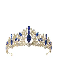Detailed view of an ornate golden bridal crown with sparkling blue and white crystals.