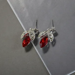 Detailed macro view of elegant silver earrings with vibrant red marquise-cut glass stones