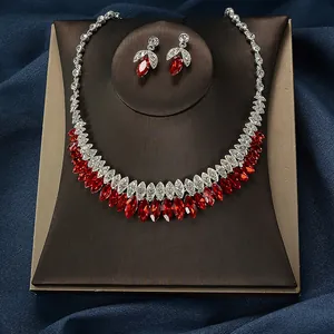 Macro view of luxury bridal jewelry set featuring red marquise crystals and silver zircon stones