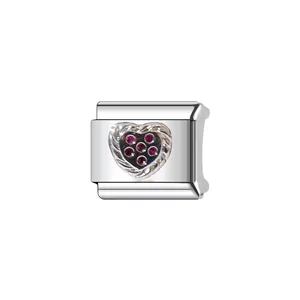 Close-up of silver Italian charm link with heart and red gemstones for DIY bracelet.