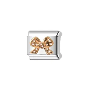 Close-up of stainless steel Italian modular charm link featuring a gold bow tie design