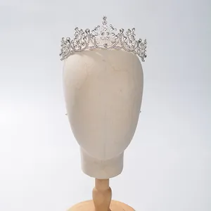 Gedetailleerd overzicht van een barokke bruidstiara met witte strassteentjes op mannequin
