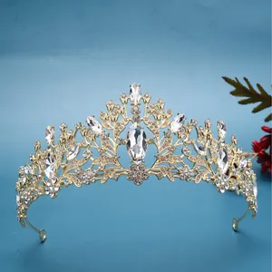 Ornate gold bridal tiara crown with sparkling marquise crystals on blue background