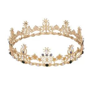 Primo piano della corona barocca dorata con strass colorati, perle e dettagli a farfalla.