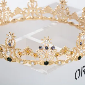 Dettaglio di corona barocca vintage con strass colorati, perle e motivi a farfalla