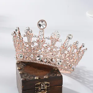 Detailopname van een barokke roségouden tiara met witte strassteentjes op kistje
