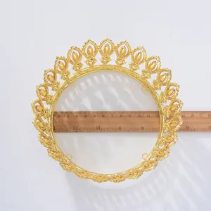 Detailed macro view of a gold Baroque round bridal tiara measured with a wooden ruler