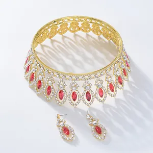Detailed view of gold baroque bridal tiara and red crystal earrings set for weddings.