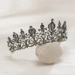 Detailed view of a vintage baroque bridal tiara with black crystals on a fabric prop.