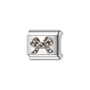 Close-up of a silver stainless steel Italian charm module with a cute bow tie pattern