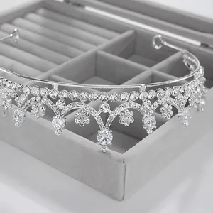 Close-up of an elegant silver bridal crystal tiara on a grey velvet jewelry box.