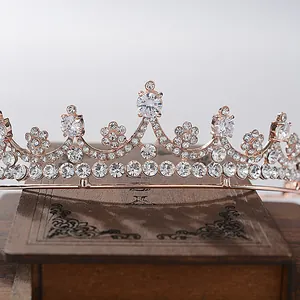 Macro detail of an elegant bridal tiara featuring sparkling crystals on a wooden base