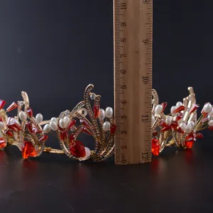 Macro-opname van gouden barokke bruidskroon met rode kristallen en witte parels