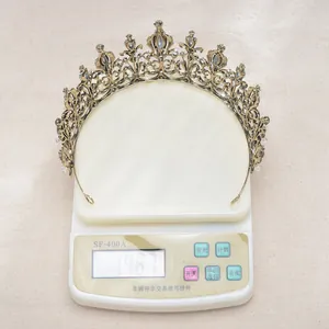 Detail view of a vintage Baroque black crystal crown being weighed on a scale, 148.7g.