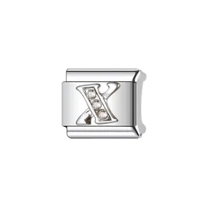 Dettaglio macro del charm modulare in acciaio inox argento con lettera X e cristalli