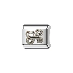 Macro detail of polished silver stainless steel Italian modular charm for DIY jewelry