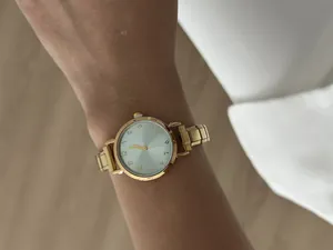 Detailopname van een elegant goudkleurig roestvrijstalen dameshorloge met kwartsuurwerk